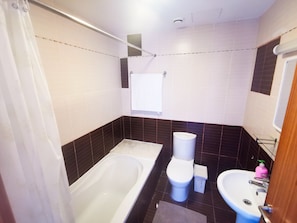 Un baño con bañera, inodoro y lavabo.