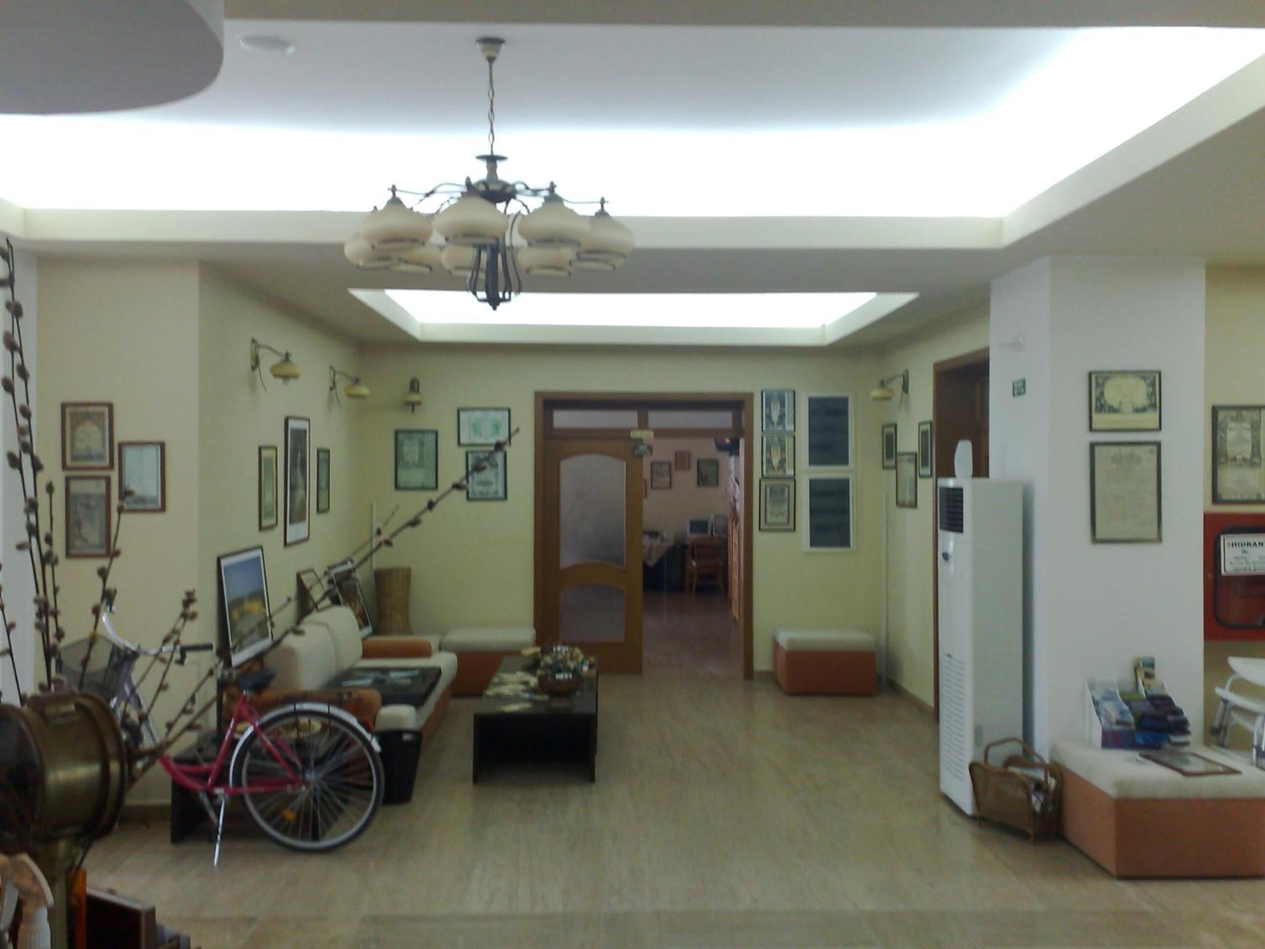 Un ampio soggiorno con soffitto alto, un lampadario, una bicicletta e un divano.