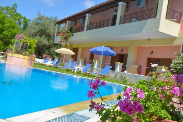 Una piscina al aire libre de temporada, sombrillas, tumbonas