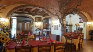 Un restaurante con arcos de ladrillo, mesas y sillas de madera.
