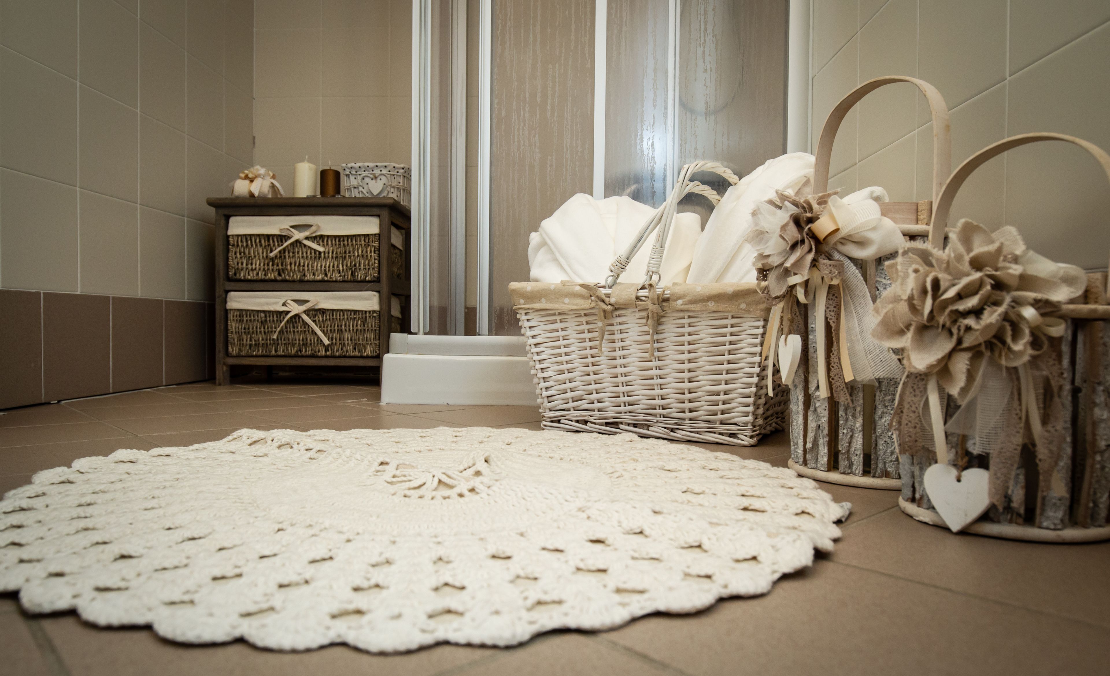 A bathroom with a wicker basket, a white doily, and a heart-shaped container.