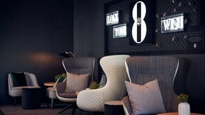 A modern lounge area with three upholstered chairs, a small round table, and a wall-mounted sign with the number 8. - Gr8 Hotel Bodegraven (Bodegraven)