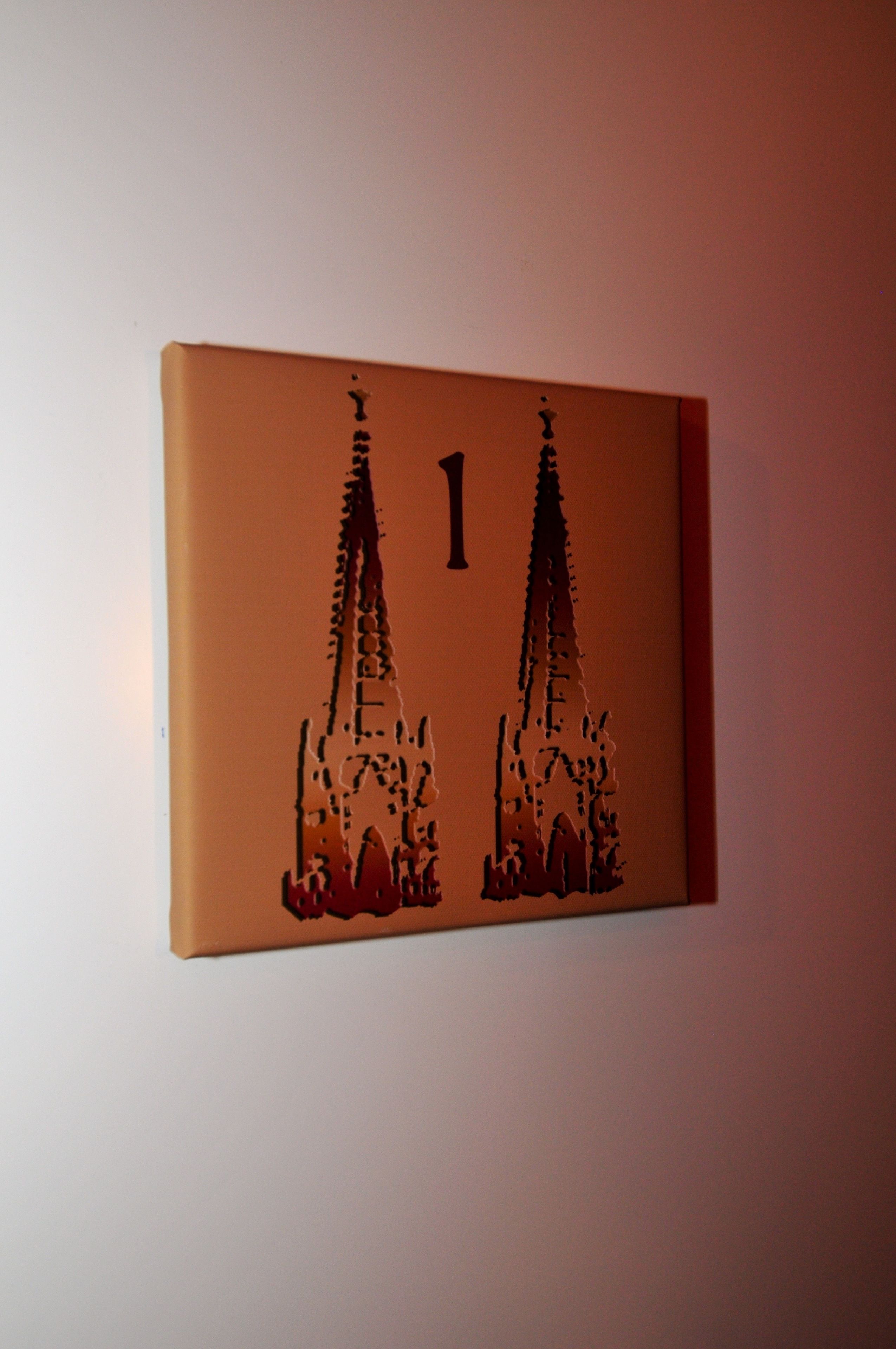 A wall-mounted sign with a number '1' and a silhouette of two towers.