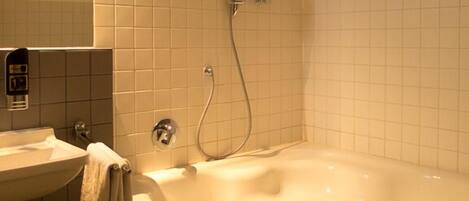 A bathroom with a bathtub, a sink, and a shower.