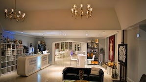 A modern hotel lobby with a bar area, seating, and a chandelier. - Hotel Monte Christo (Cologne)