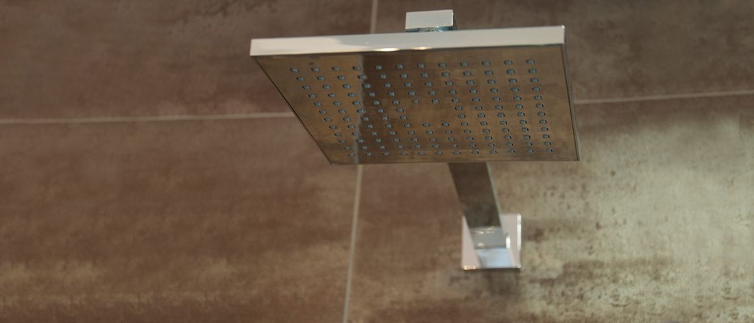 Un cabezal de ducha montado en una pared con azulejos.