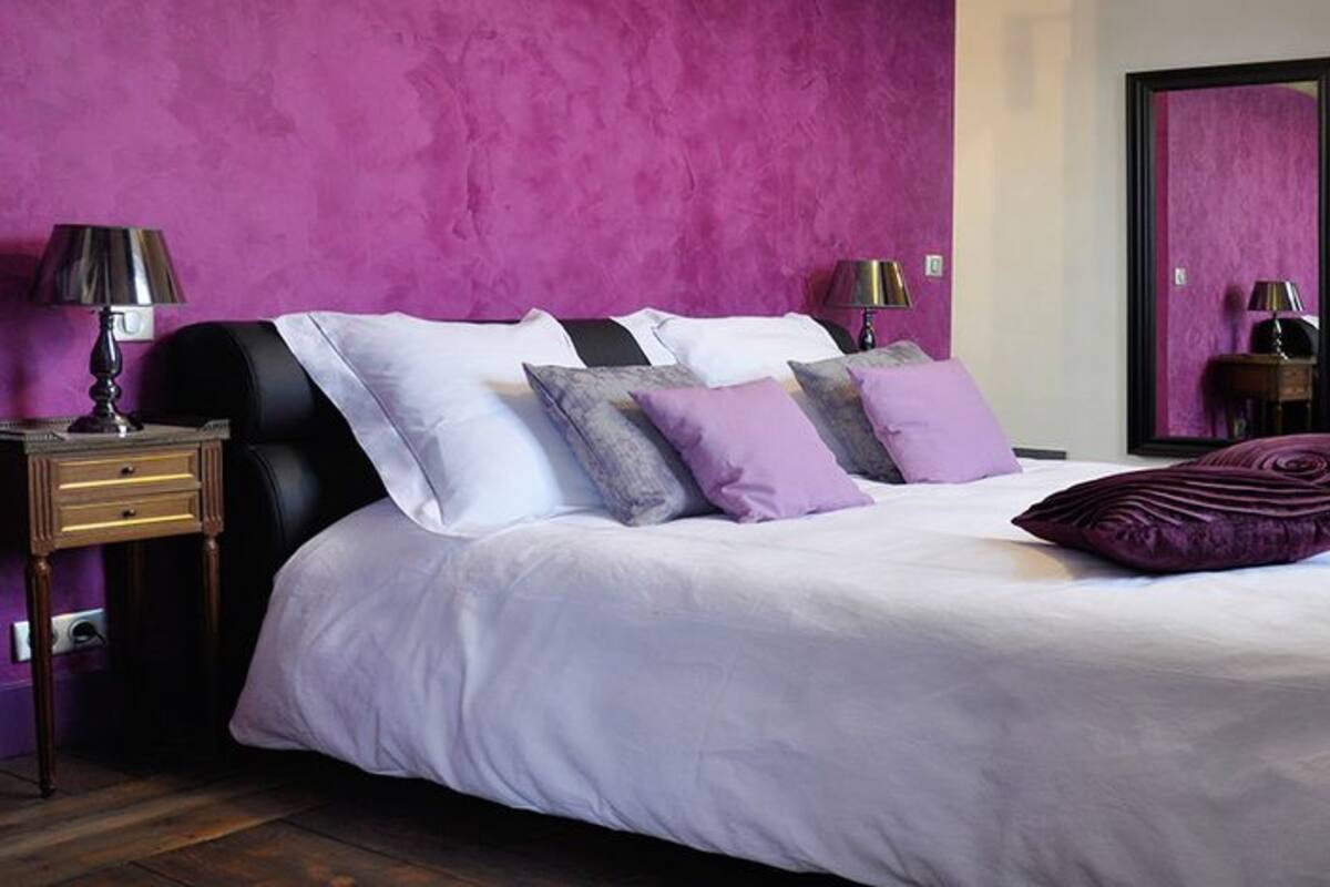 Un dormitorio con cama, mesitas de noche, cómoda y televisor.