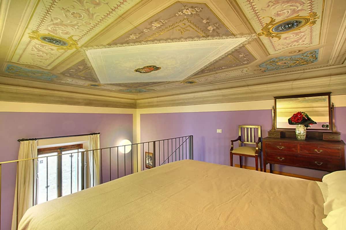 Une chambre à coucher avec un lit, une commode, une chaise et un miroir.