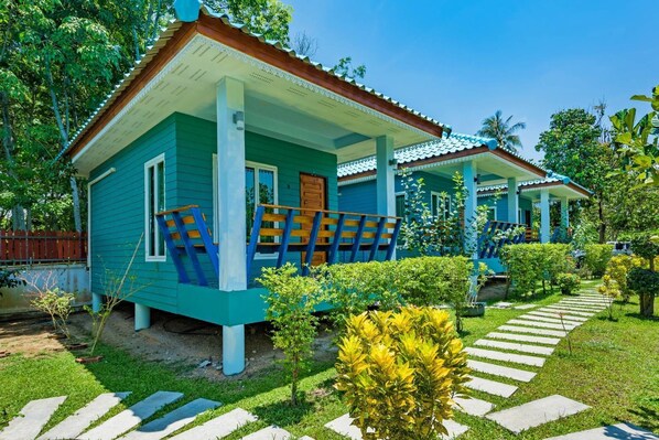 A two-story house with a porch and a garden pathway. - Rat Villa (Pa Klok)