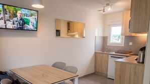 A modern kitchen with wooden cabinets, a built-in oven, and a sink. - VVF Méjannes Gard, Méjannes le Clap (Mejannes-le-Clap)
