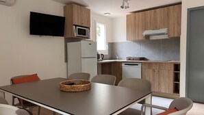 Moderni keittiö, jossa on puukalusteet, sisäänrakennettu mikroaaltouuni ja astianpesukone.