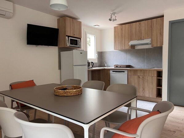 A modern kitchen with wooden cabinets, a built-in microwave, and a dishwasher.