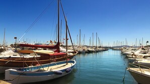 A marina with various boats docked, clear skies, and calm water.