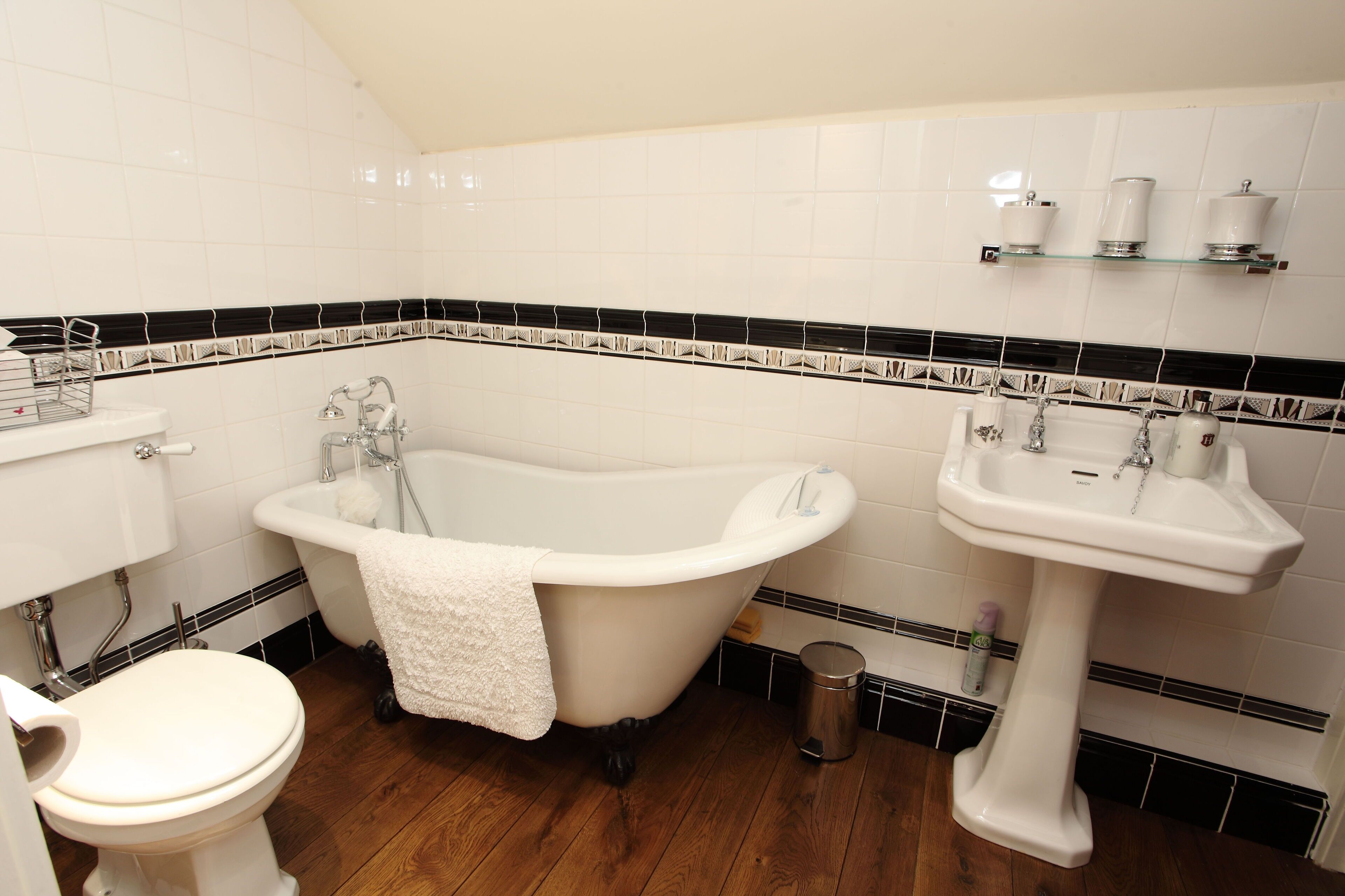 A bathroom with a freestanding bathtub, a pedestal sink, and a toilet.
