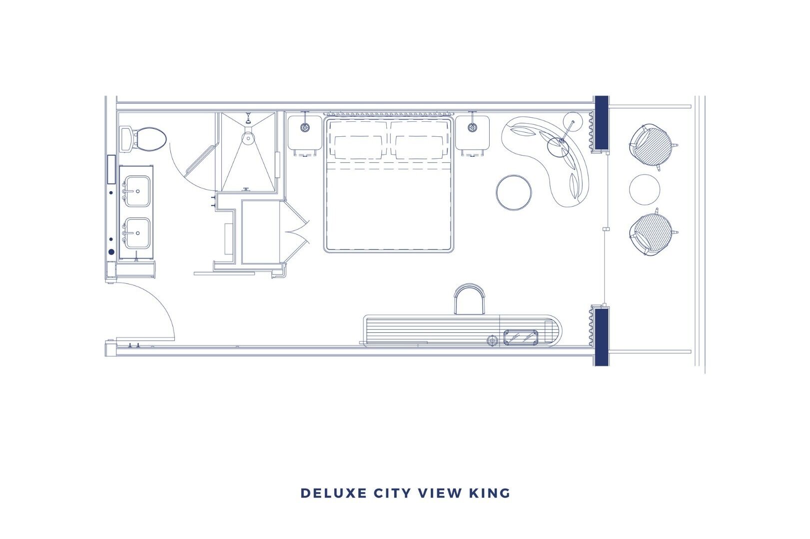 A floor plan of a hotel room labeled "Deluxe City View King," featuring a large bed, a separate bathroom, a small seating area, and a view of the city.