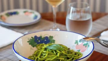 A dining table with various dishes, including pasta and a glass of white wine.
