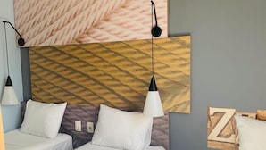A hotel room with two beds, a large wall art piece, a wooden headboard, and a bedside table with a lamp. - ibis Parauapebas (Parauapebas)