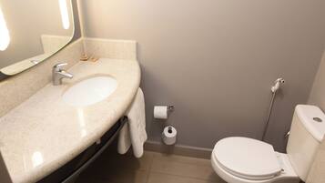 Un baño con lavamanos, inodoro y espejo.