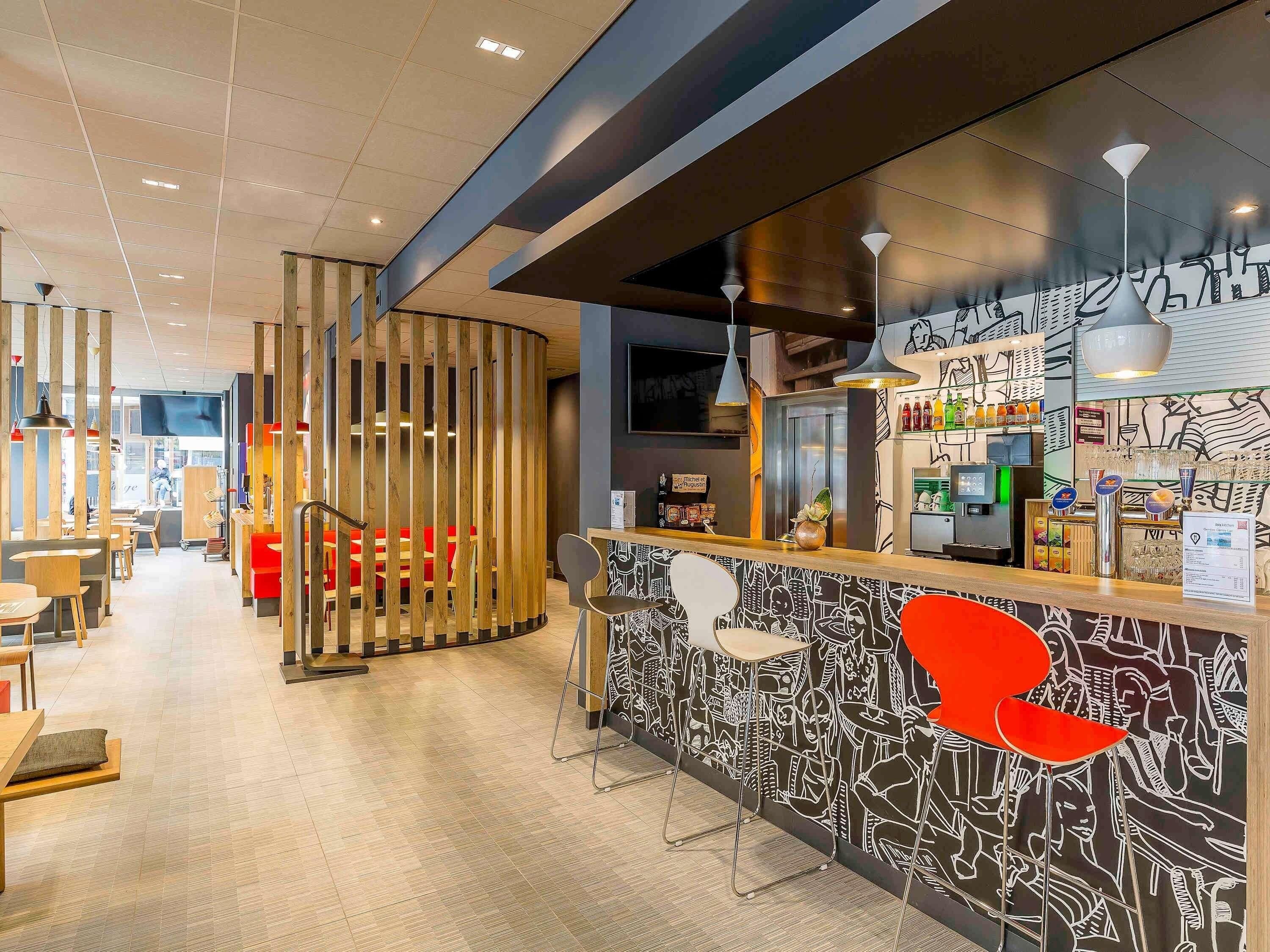 A modern bar area with a counter, seating, and a decorative wall.
