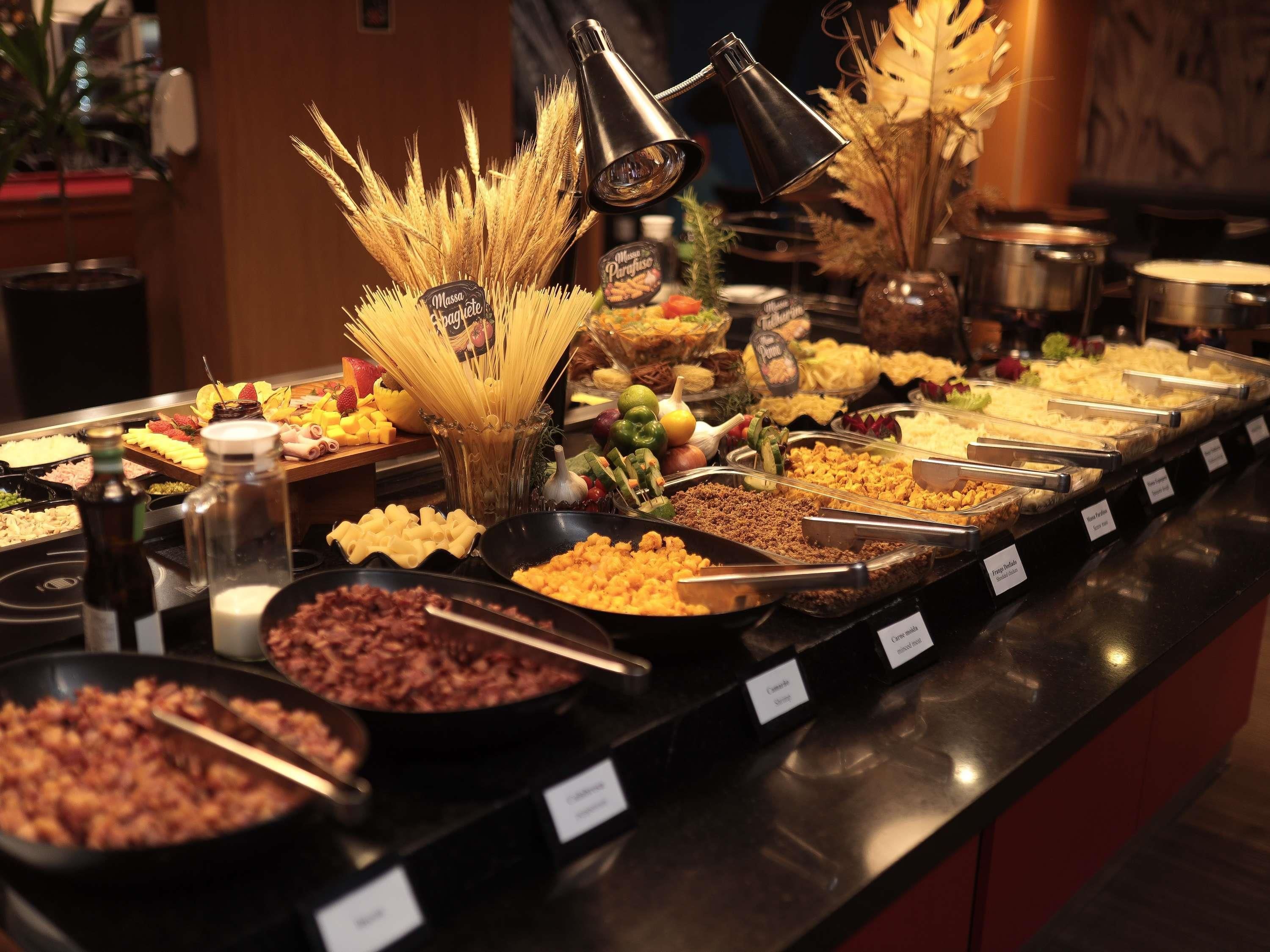Un bufé con diversas opciones de comida, incluyendo pasta, ensaladas y carnes.