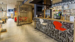 A modern bar area with a counter, seating, and a decorative wall. - ibis Parauapebas (Parauapebas)