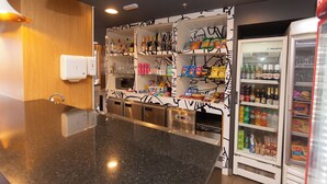 A modern kitchen with granite countertops, a built-in microwave, and a refrigerator stocked with beverages and snacks. - ibis Parauapebas (Parauapebas)