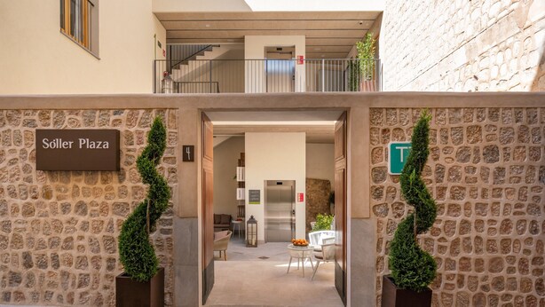 Una entrada de paredes de piedra a un edificio con un letrero que dice "Söller Plaza".