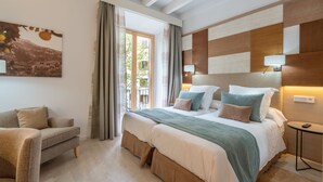 Un dormitorio moderno con una cama grande, un sofá y un cuadro en la pared.
