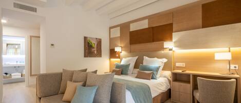 A modern bedroom with a large bed, a sofa, a desk, and a chair.