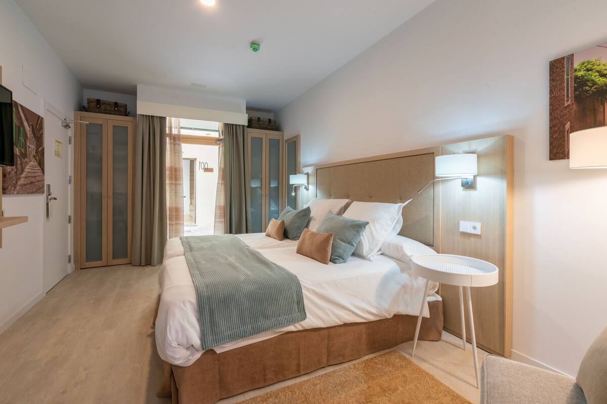 Ein Schlafzimmer mit einem großen Bett, einem Nachttisch, einer Lampe und einem Kleiderschrank.