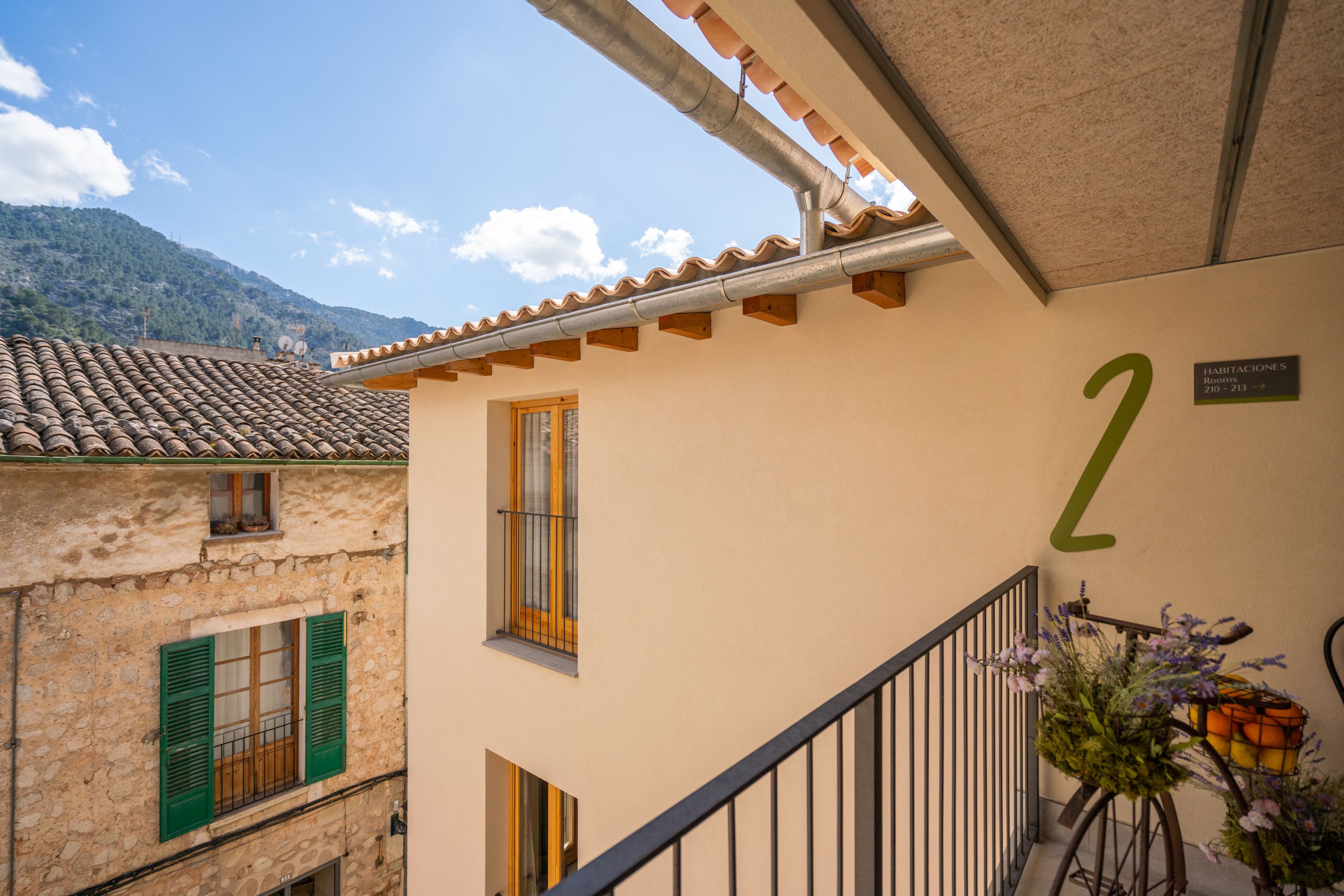 Ein Gebäude mit Balkon, einer Beschilderung mit der Nummer 2 und Blick auf einen Berg.