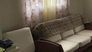 Un salon avec un canapé, un téléphone et un interrupteur fixé au mur.