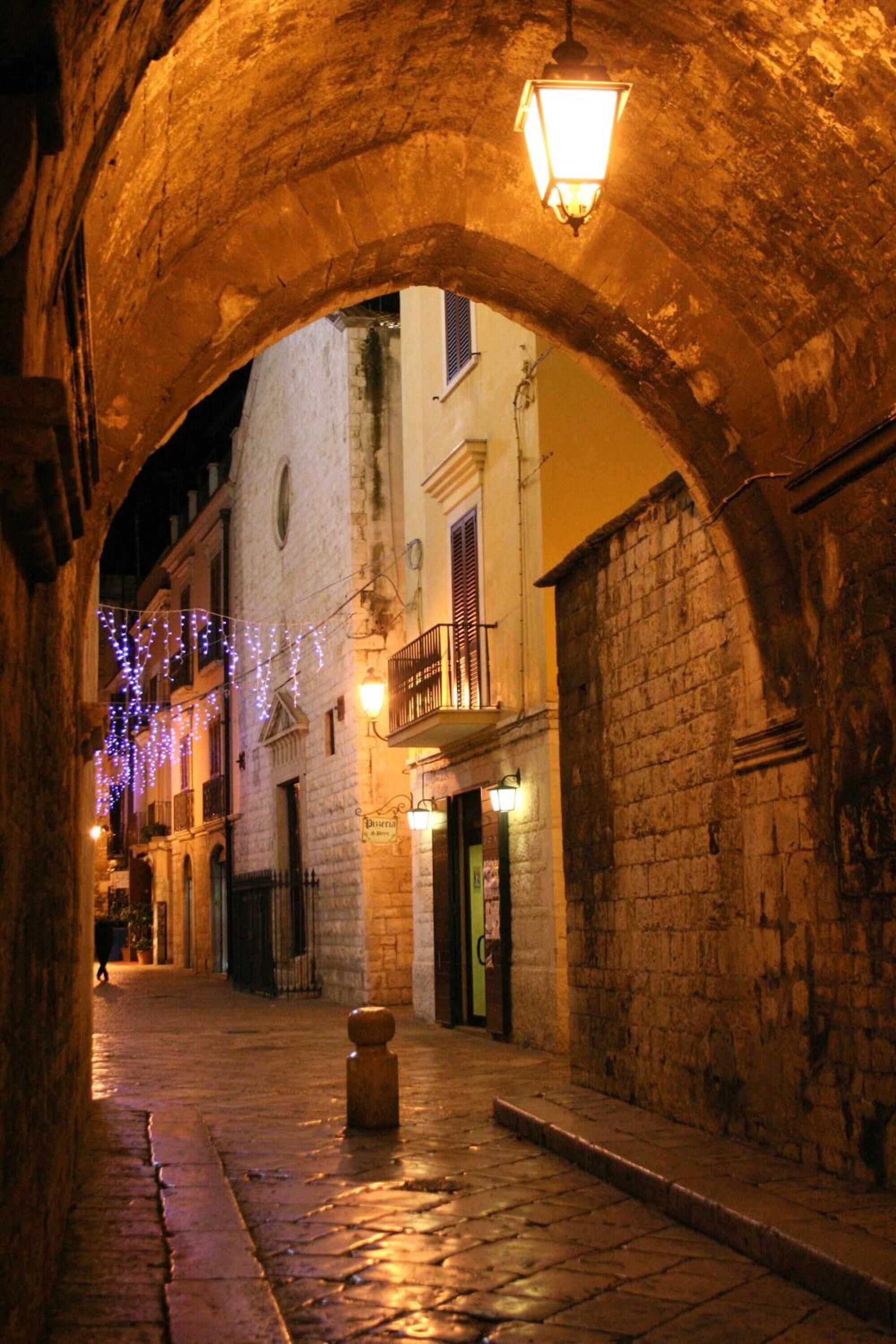 Una estrecha calle flanqueada por muros de piedra y un topógrafo de madera.
