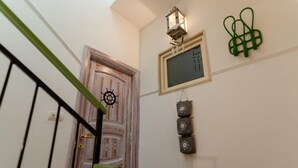 A staircase with a wooden door, a wall-mounted light fixture, and decorative wall art. - Domatia (Barletta)