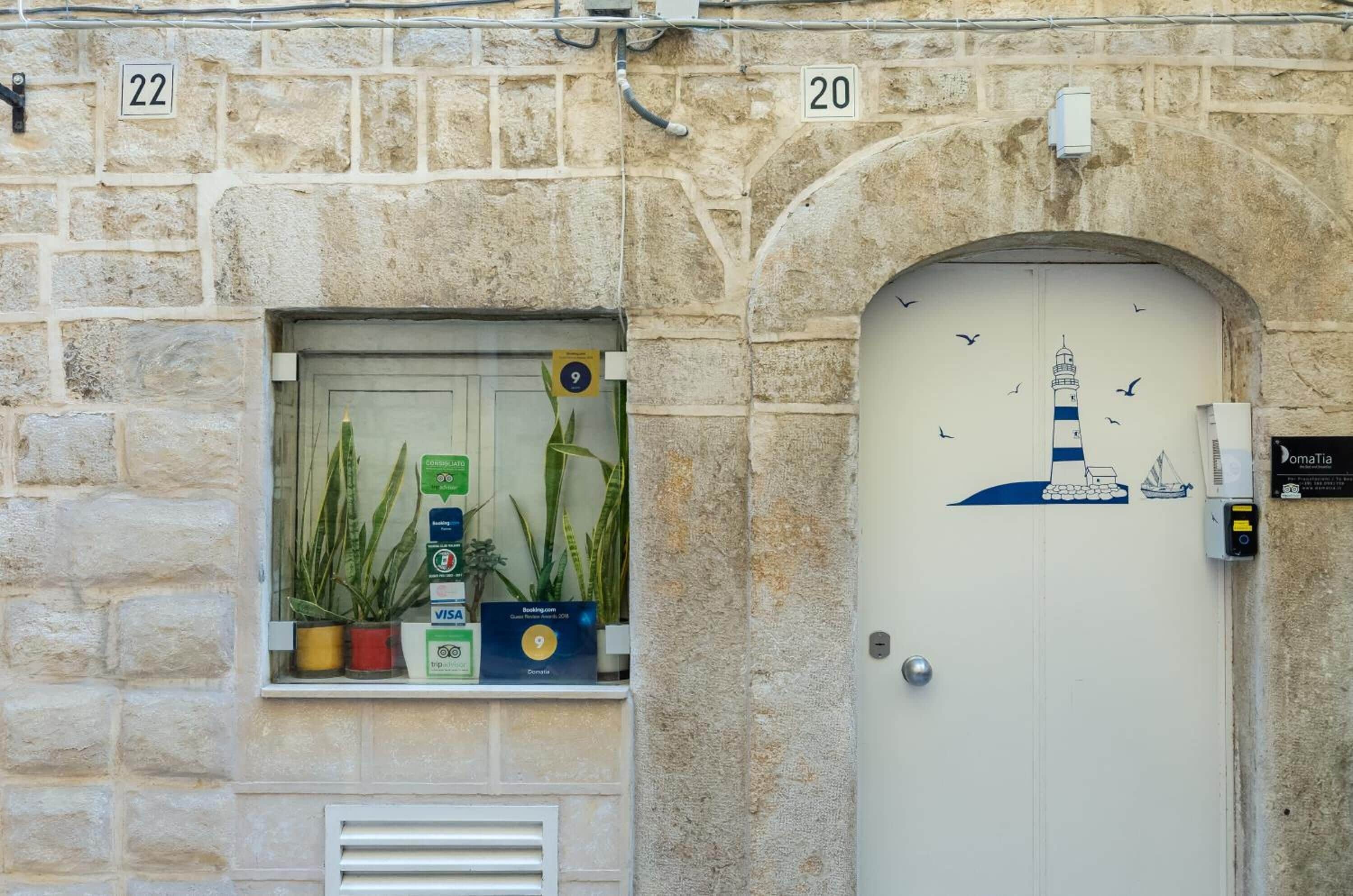 A stone building with a window displaying plants and payment options.