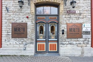 A double door with ornate designs and two signs on either side.
