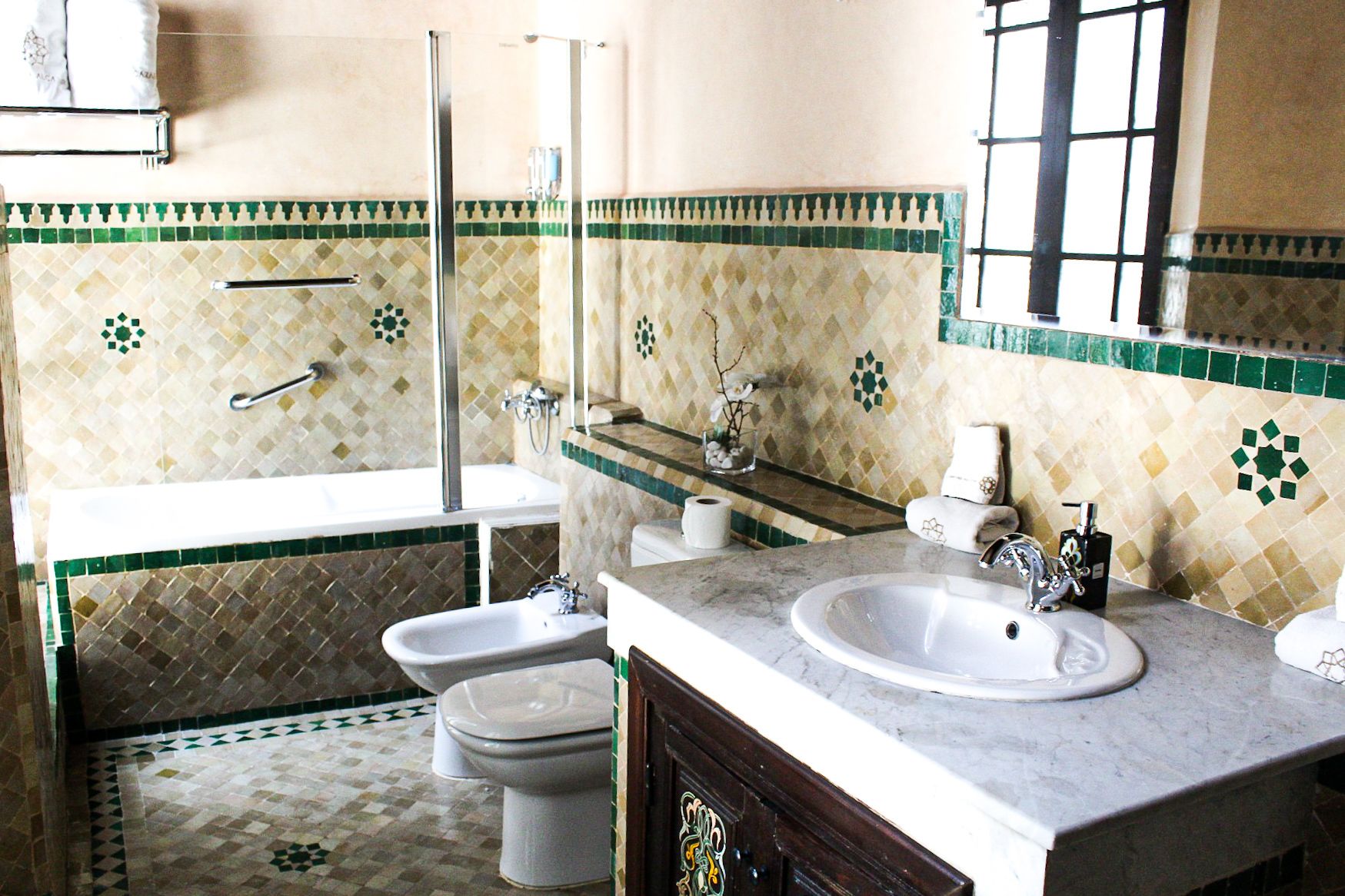 Un baño con bañera, dos lavabos, inodoro y ducha.