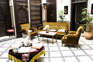 Um interior em estilo marroquino com um sofá, uma mesa de centro e uma poltrona.