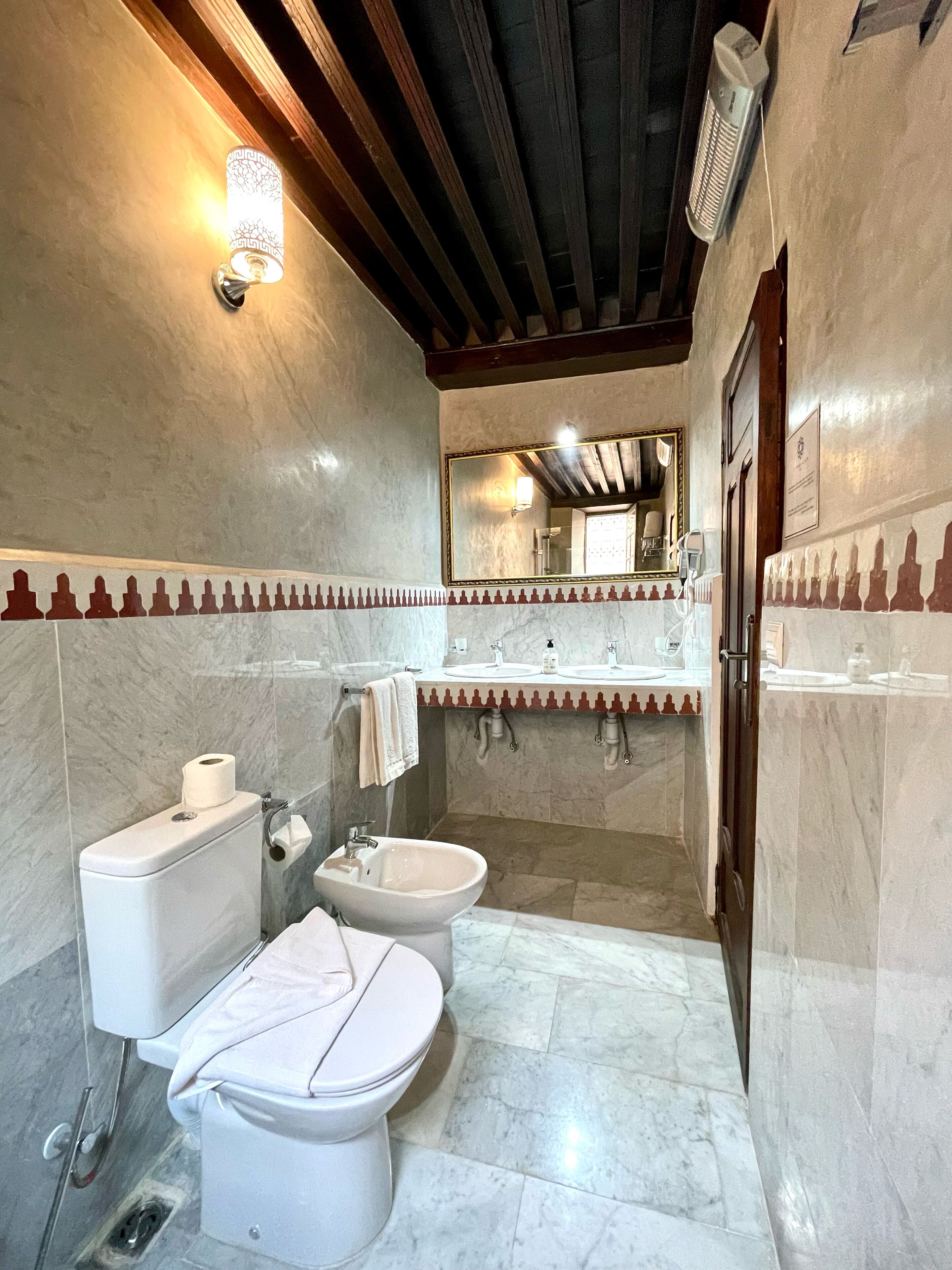 A bathroom with a toilet, bidet, and sink.