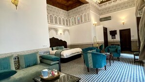 Un interior tradicional marroquí con suelo a cuadros, paredes con diseños y techo de madera.