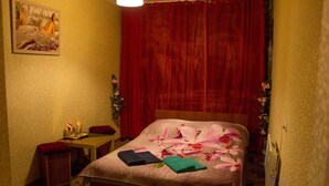 A hotel room with a bed, a desk, a chair, and a painting on the wall. - U Svetlany (Cheboksary)