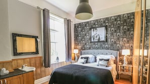 Un dormitorio con una cama grande, un tocador con espejo y una pared con diseño.