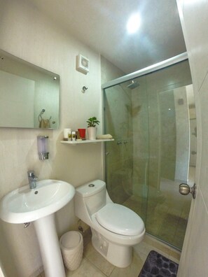 A bathroom with a sink, toilet, and glass-enclosed shower. - Hospedaje Tlaquepaque (Tlaquepaque)