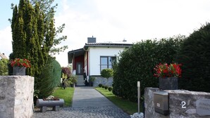 A modern house with a stone pathway leading to the entrance, a mailbox, and a number plaque. - Ferienwohnungen Schlossblick (Braunfels)