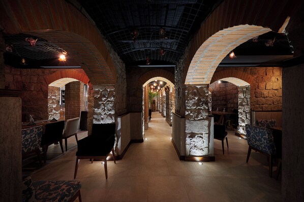 An interior with brick walls, arched ceilings, and a central walkway.