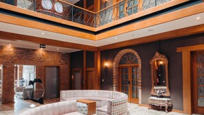 A spacious lobby with a central seating area, a staircase, and a decorative mirror. - Hotel Cruz del Vado by Art Hotels Ecuador (Cuenca)