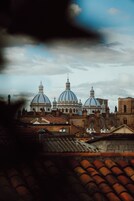 Un edificio histórico con grandes cúpulas y un campanario.