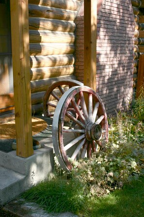 Une cabane en bois, avec une grande roue de moulin rustique appuyée contre la structure.
