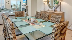 Un coin repas avec une table à plateau en verre, des chaises en osier et un vase contenant des objets décoratifs.