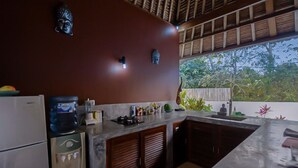 Une cuisine dotée d’un grand îlot central, de meubles en bois, d’un réfrigérateur et d’un distributeur d’eau.